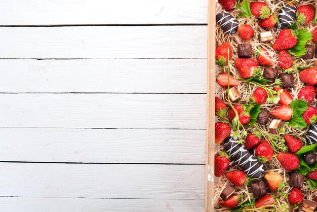 Aardbei met chocolade in een houten kist Op een houten achtergrond Bovenaanzicht Kopieer de ruimte