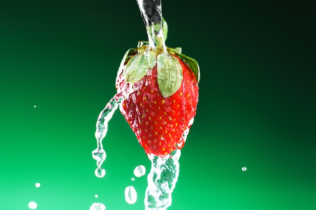 Aardbei op een groene achtergrond met dalingen van water