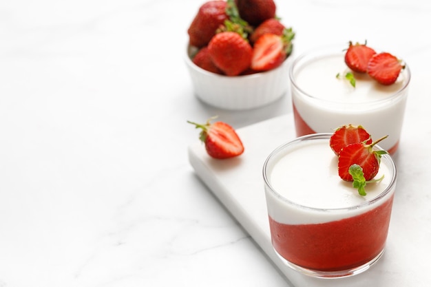 Aardbei romig dessert panna cotta met aardbei in glazen potten met verse bessen en munt