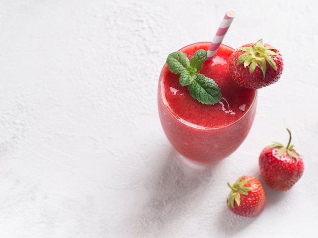 Aardbei smoothie en verse rauwe bessen op wit