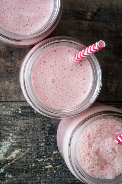 Aardbei smoothie in pot op houten tafelblad bekijken