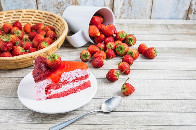 Aardbeicakes en vers aardbeifruit op een houten lijst