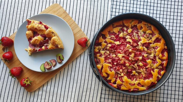 Aardbeien- en rabarbercake op een bord en in bakvorm