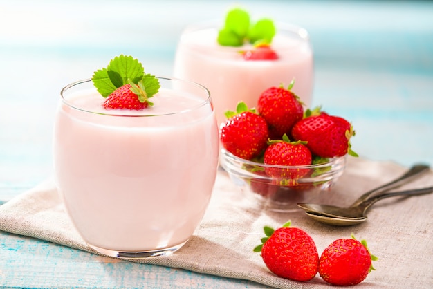 Aardbeien en roze yoghurt op een houten tafel