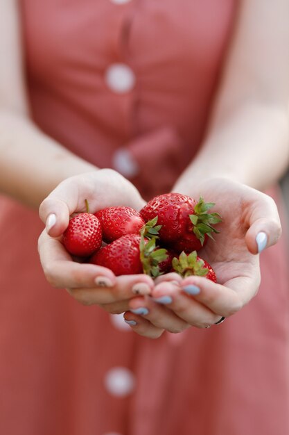 Aardbeien in de handen van een wazig meisje