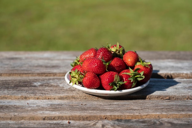 Aardbeien in een bord op een houten tafel