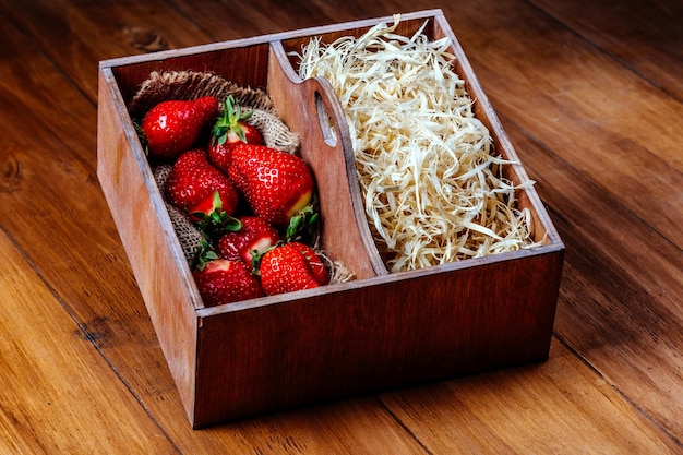 Aardbeien in een houten kist op een houten ondergrond