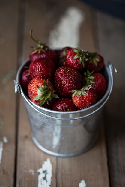 Aardbeien in emmers op een houten tafel