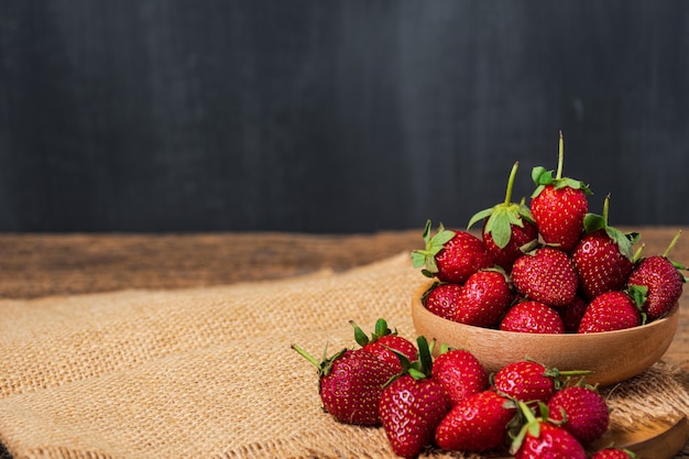 Aardbeien in houten kom met jute Aardbeienachtergrond Copyspace voor tekst