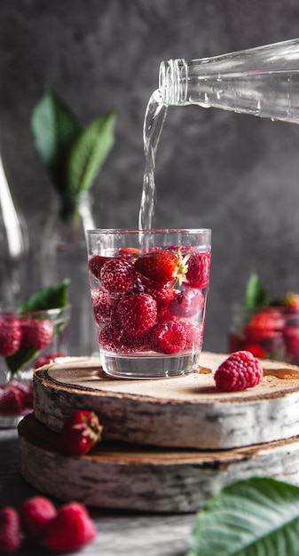 Aardbeien in water op een donkergrijze achtergrond. gezond eten, fruit. een boeket bloemen als decoratie