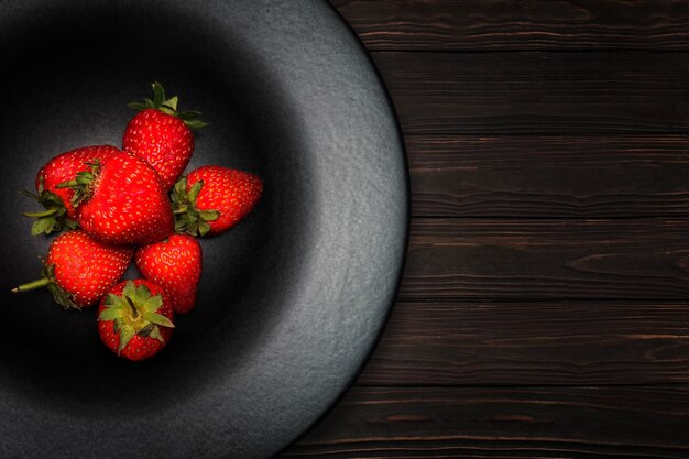 Aardbeien op een bord op een houten ondergrond