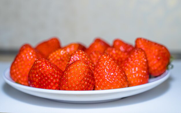 Aardbeien op een wit bord op een witte tafel Selectieve focus