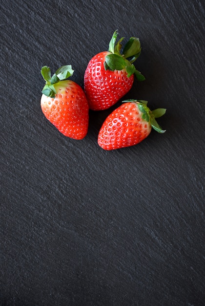 Aardbeien op een zwarte leisteen tafel klaar om te worden gebruikt