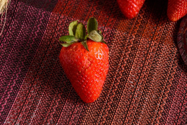 Aardbeien op rood getextureerd tafelkleed