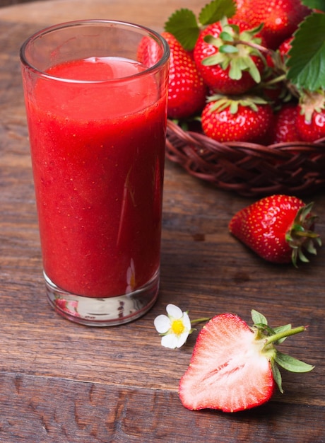 Aardbeien smoothie in glazen pot over oude houten tafel