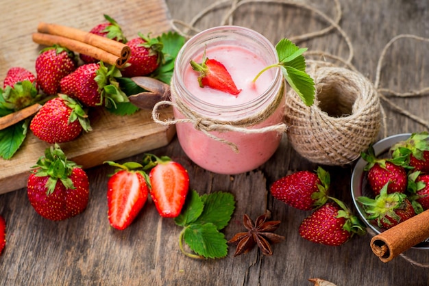 Aardbeien smoothies in glas met veel aardbeien op houten achtergrond. Bovenaanzicht. Ruimte kopiëren