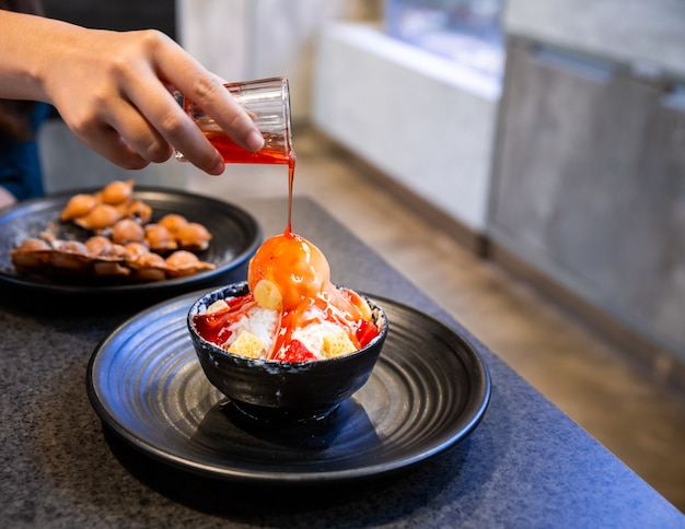 Aardbeienaus met de hand gieten op bingsu.