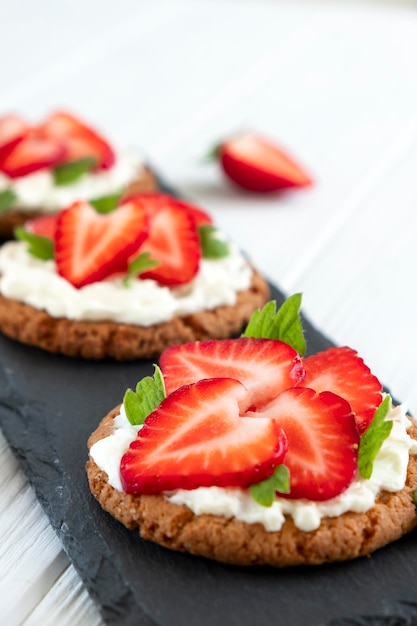 Aardbeienbruschetta op roggebrood met kwark en munt Gezonde snack keto-dieet of dieetconcept Recept van veganistisch eten voor dagelijks koken