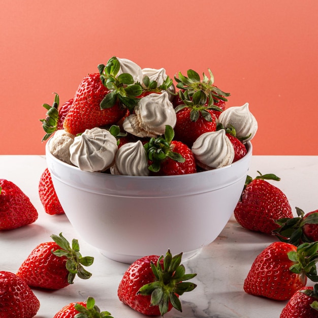 Aardbeiendessert met dulce de leche meringue geserveerd in een kom op een marmeren achtergrond