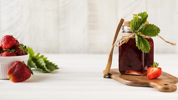 Aardbeienjam in een pot op een houten bord gefermenteerde bessen kopieer ruimte