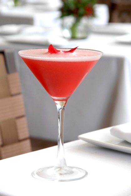 Aardbeienmartini gegarneerd met rozenblaadjes op een lifestyle-drankje op een restauranttafel