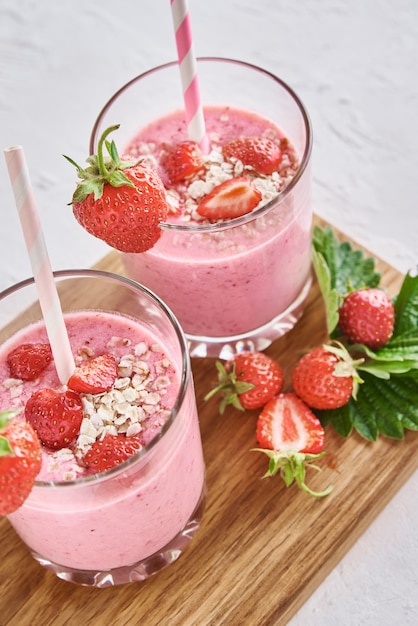 Aardbeienmilkshake in glas met stro en verse bessen