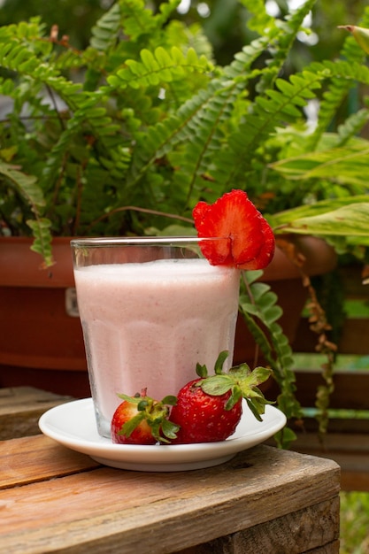 Aardbeiensmoothie met vers fruit en melk in een glas met fruitdecoratieontbijt