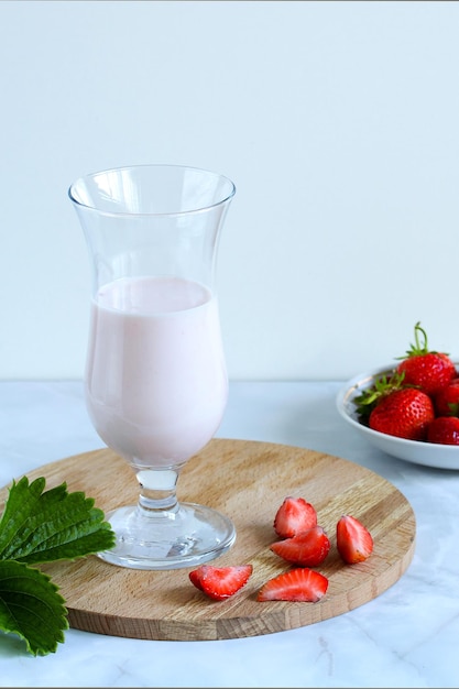 Aardbeienyoghurt een drankje in een glas en rauwe rijpe bessen