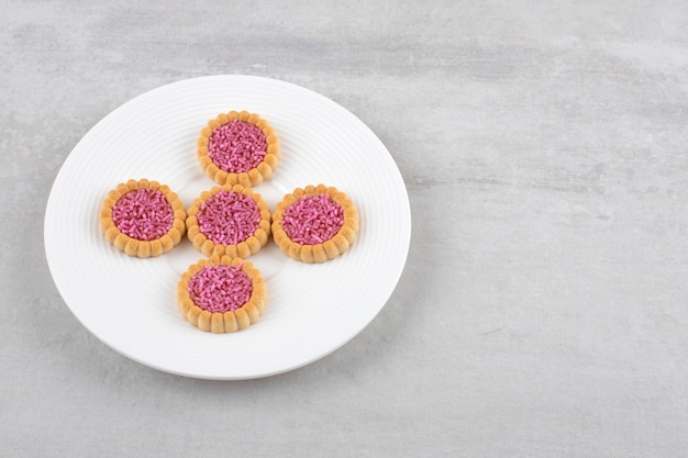 Aardbeigelei koekjes op een schaal, op het marmer.