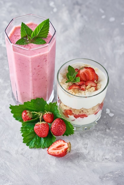 Aardbeimilkshake in een glazen pot en verse aardbeien met bladeren