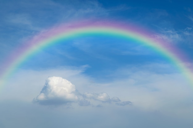 Aardcloudscape met blauwe hemel en witte wolk met regenboog