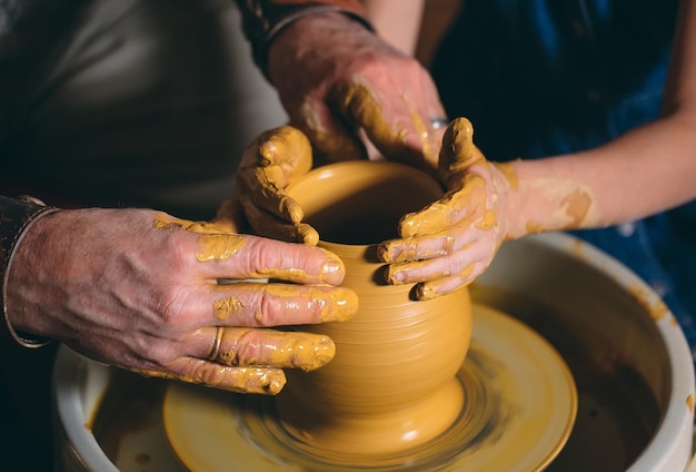 Aardewerk workshop. Opa leert kleindochter aardewerk. Modelleren van klei.