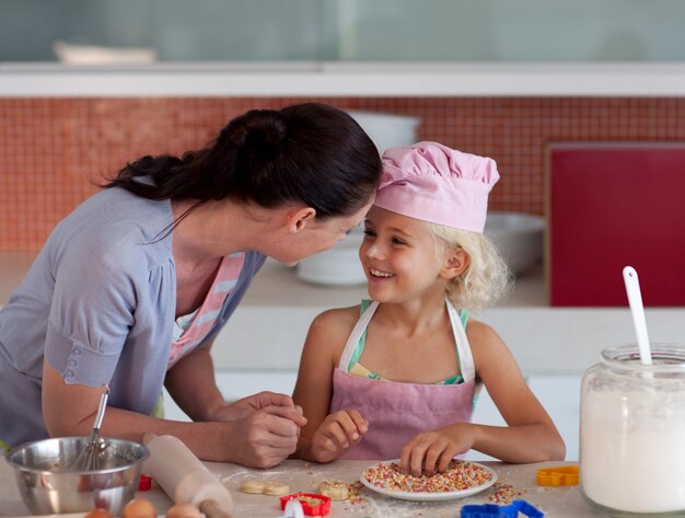 Aardige moeder en haar dochter die in een keuken bakken