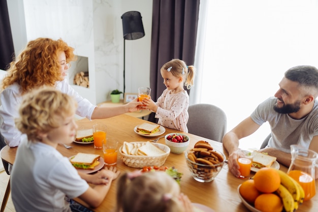 Aardige zorgzame moeder die sap geeft aan haar dochter