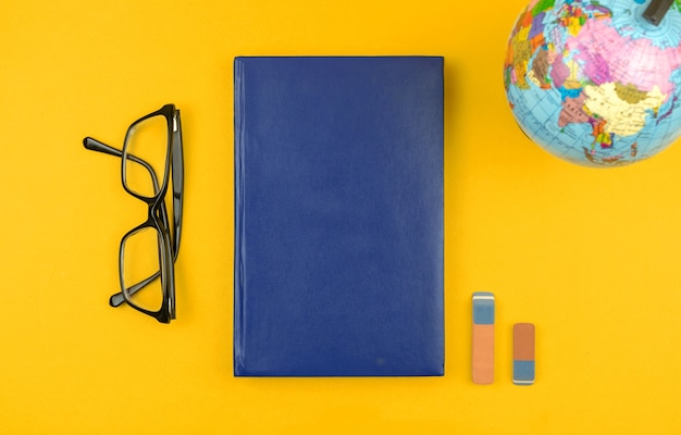 Aardrijkskundeonderwijs plat lag en mockup achtergrond met de wereldbol en lege blauwe boekglazen op de...