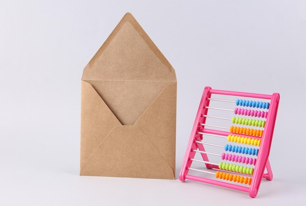 Abacus and craft envelope on white background