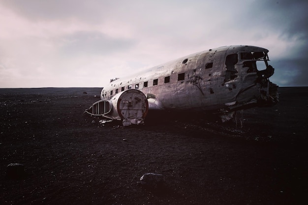 abandoned airplane on sand against sky