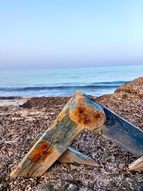 Foto barca abbandonata sulla spiaggia contro un cielo limpido