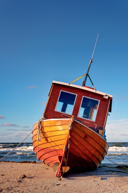 Abandoned boat moored on beach against clear blue sky