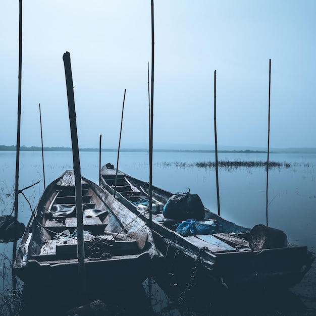 Photo abandoned boats moored in sea against sky