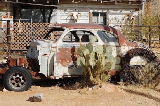 Фото Заброшенная машина у старого дома в солнечный день