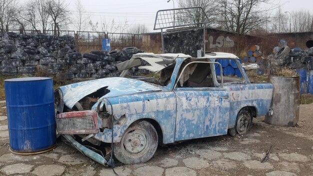 Abandoned car parked on bare tree