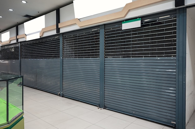 Abandoned closed shutter shop in department store from economic condition