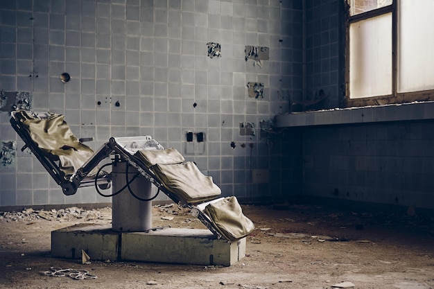 Abandoned dental room with an old chair and ruined walls under the lights