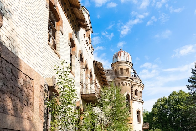 Photo abandoned estate of merchants eliseevs facade among green trees st petersburg russia august 2022