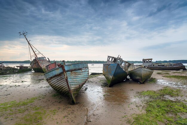 Abandoned fishing boats under a brooding sky