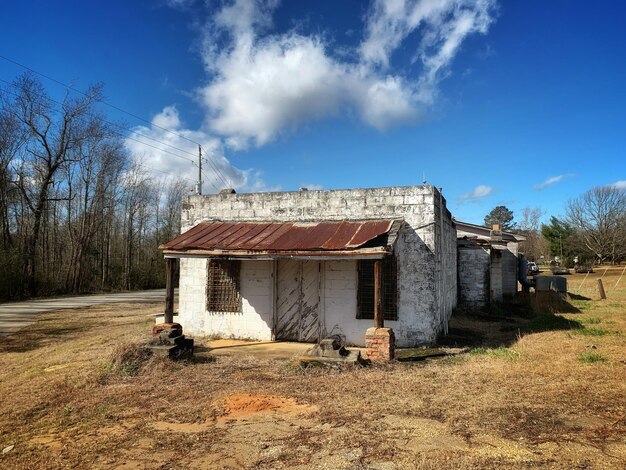 Abandoned house on field against sky