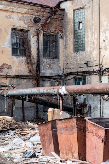 Foto casa abbandonata e rovine, vicino al bidone della spazzatura