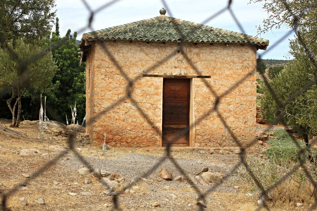 Foto casa abbandonata vista attraverso la recinzione a catena