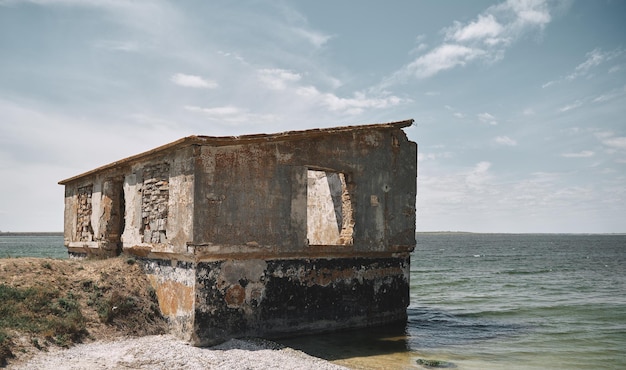 Abandoned industrial building on the seashore vintage\
industrial house destroyed by sea water